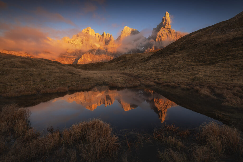 Cimon della Pala glowing at sunset above an alpine pond, Dolomites
